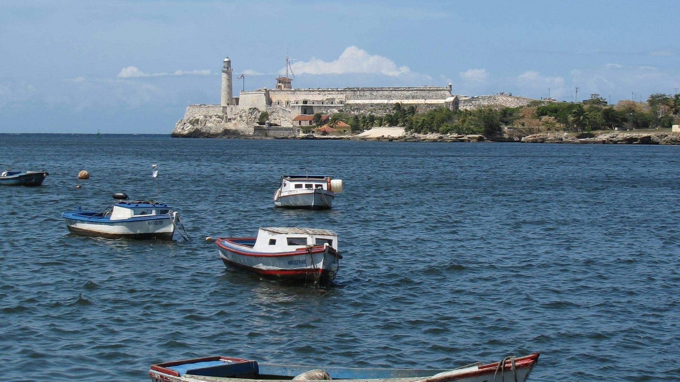 Fishing boats in Havana harbour below the Castillo del Morro and its lighthouse, Cuba