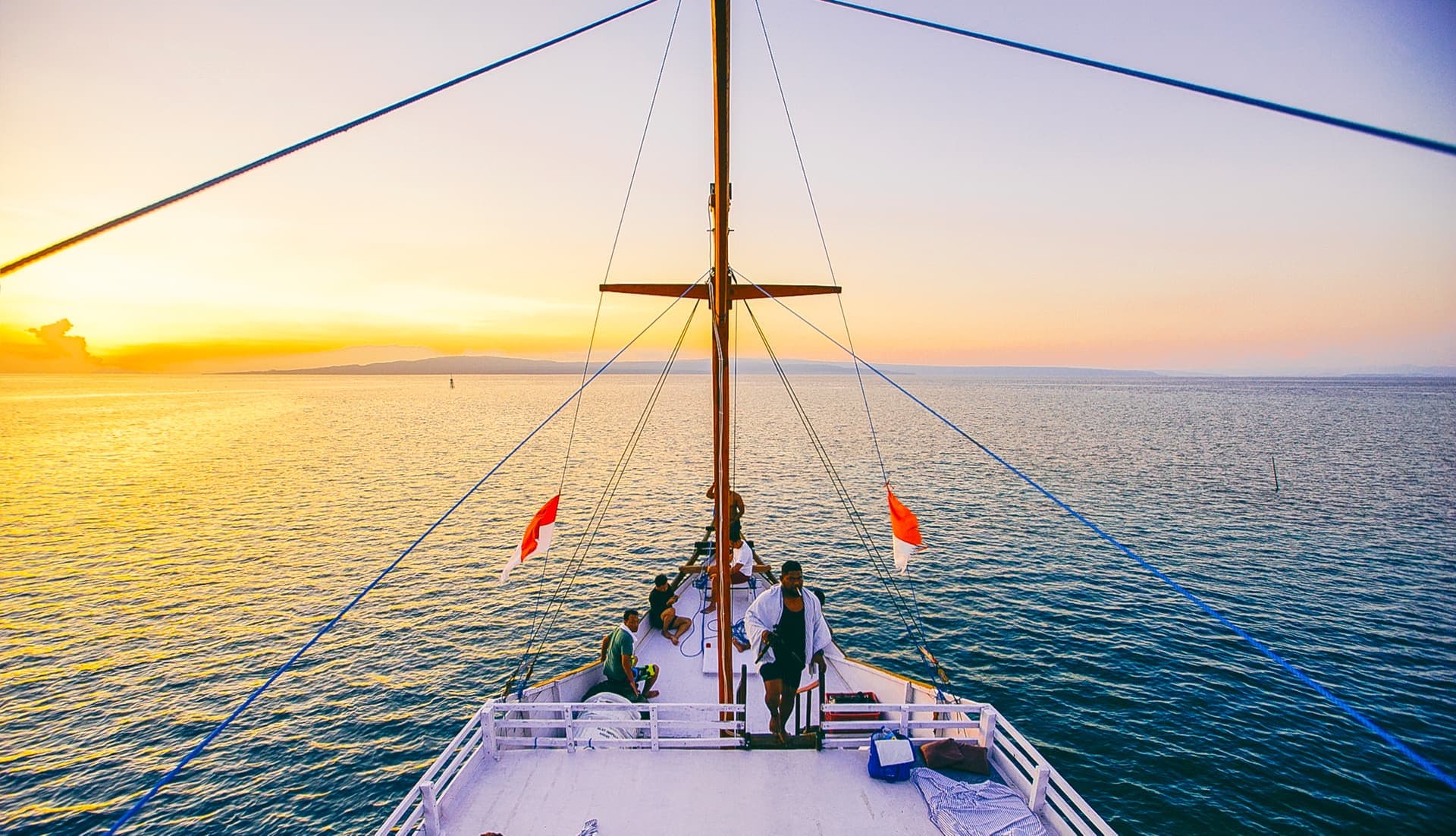 Guests on the deck of a yacht at sunset