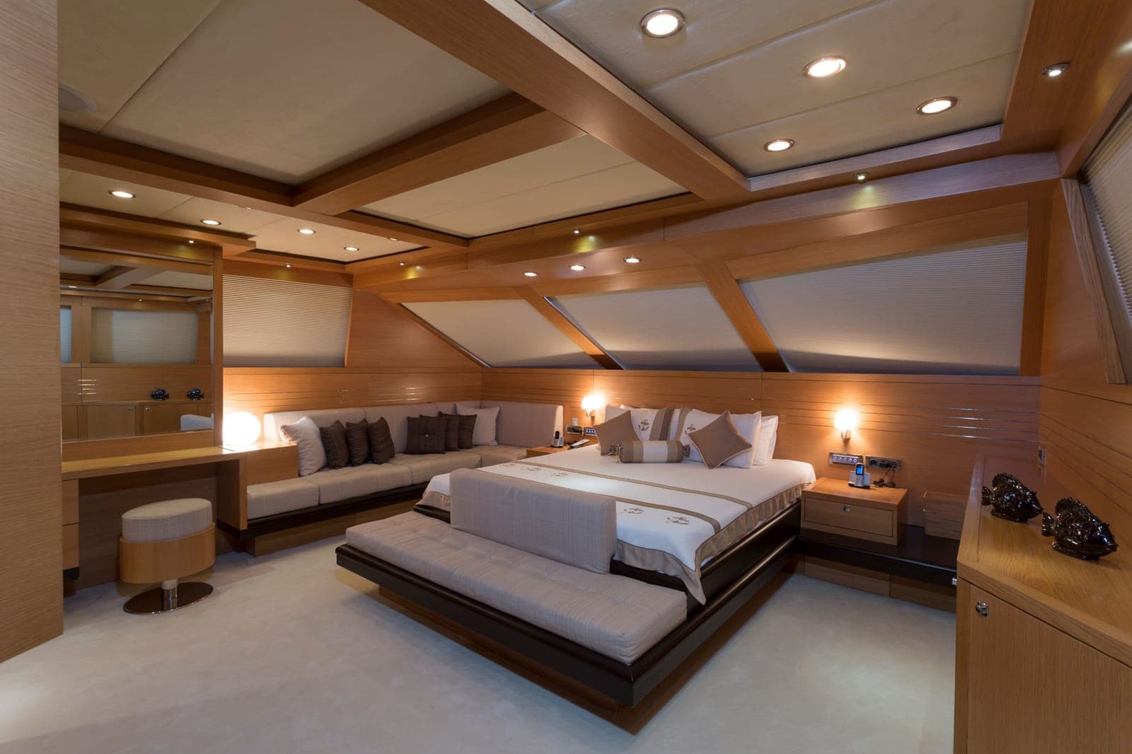 A master cabin on a yacht with a double bed and a lounge sofa