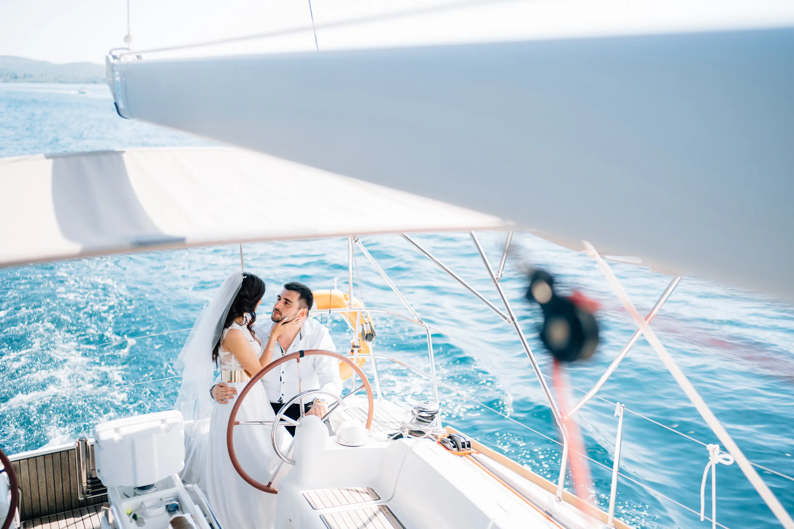 Bride and groom at the helm of a yacht